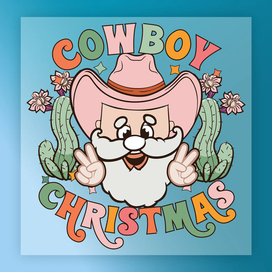 InkMerge's Cowboy Christmas Santa Design features Santa in a pink cowboy hat flashing peace signs amid cacti and flowers, with "COWBOY CHRISTMAS" in bold colors on blue—perfect for heat press or DTF transfer.