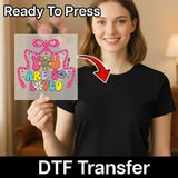 A smiling woman holding a sign with a colorful design and text.