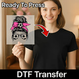 A woman is holding up a clear image of a soccer ball with a pink ribbon on her head, and there is text overlay that says "Ready To Press" and "DTF Transfer".