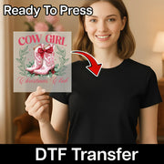 A smiling woman in a black t-shirt holds the Cowgirl Christmas Club DTF transfer by InkMerge, featuring pink cowboy boots, flowers, and festive text. An arrow points to the sheet with "Ready To Press" above—perfect for holiday DTF projects!.
