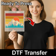A smiling woman in a black t-shirt holds InkMerge’s Retro Mountain Landscape DTF transfer sheet featuring mountains, trees, and a sunset. A red arrow points to her shirt with “Ready To Press” and “Direct-to-Film transfer” text.