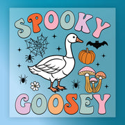The image is a colorful illustration featuring a cartoon goose surrounded by various Halloween-themed elements, including a spider, pumpkin, mushrooms, and a bat.