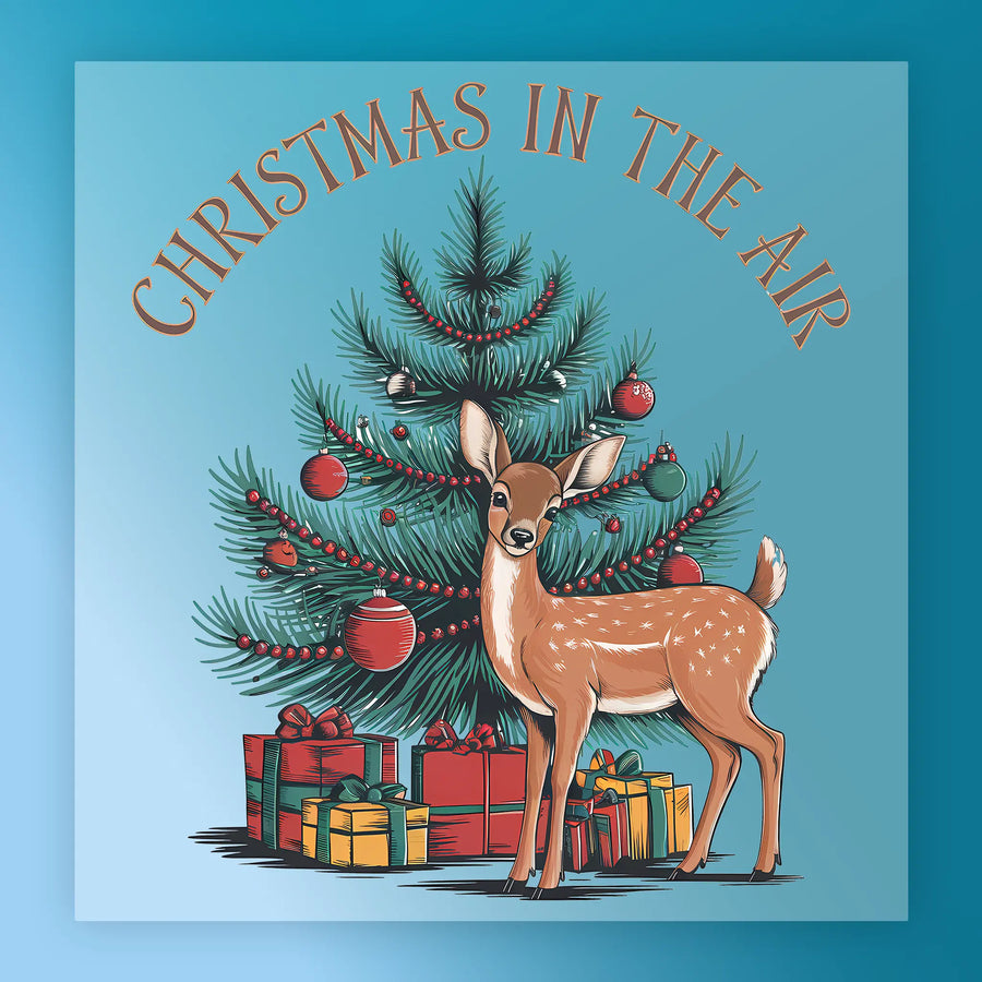 A deer stands before a decorated tree with red ornaments and gifts. "CHRISTMAS IN THE AIR" appears above on blue—perfect for festive shirts or DTF transfers. Product: Christmas In The Air Festive Scene - Heat Press Ready by InkMerge.