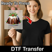 A smiling woman in a black shirt holds an InkMerge DTF transfer sheet with the Festive Christmas Pudding Design; text reads “Ready To Press” and "DTF Transfer" with a red arrow—ideal for your heat press projects.