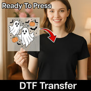 A woman is holding up a clear plastic sheet with a Halloween-themed ghost illustration on it.