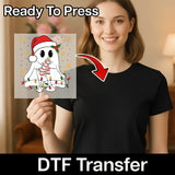 A woman is holding up a transparent sheet with a ghost illustration on it, and there is text that says "Ready To Press" and "DTF Transfer" below the image.