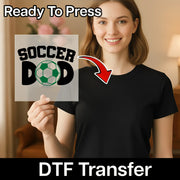 A smiling woman holding a sign with the text "SOCCER DAD" and a red arrow pointing to the sign.