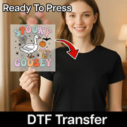 A woman is holding up a sign with a cartoon goose and Halloween-themed decorations, and there is a red arrow pointing to her chest.
