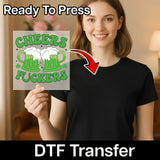 A woman holding a sign with the text "Cheers FUCKERS" and a graphic of two beer mugs.