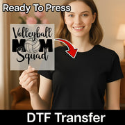 A smiling woman holding a sign with the text "Volleyball Mom Squad" and a red arrow pointing to her chest.