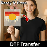 A woman in a black shirt holds InkMerge’s Good Vibes Retro Sunset DTF film with a yellow circle, red stripes, and blue triangles. "Ready To Press" and "DTF Transfer" appear with an arrow—perfect for your next heat press project.