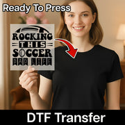 A smiling woman holding a sign with the text "Rocking this soccer dad life" and a red arrow pointing to her chest.