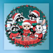 Four adorable animals—a cat, two raccoons, and a rabbit—enjoy hot chocolate outdoors at a red table in the InkMerge Festive Animal Friends Christmas Scene DTF transfer, surrounded by snow, a holiday wreath, and a festive house.